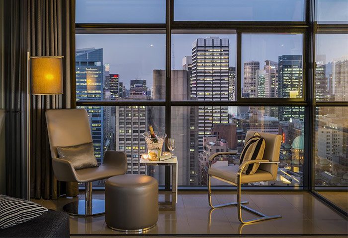 Fraser Suites Sydney luxury hotel room. Champagne, chairs, & city view. Most booked cheap hotel for gay travelers. Gay Sydney travel.