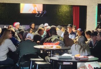 Freezone Gay Bar in Las Vegas: A crowded scene of gay men at tables in a bar setting, enjoying drinks and socializing. Nightlife.