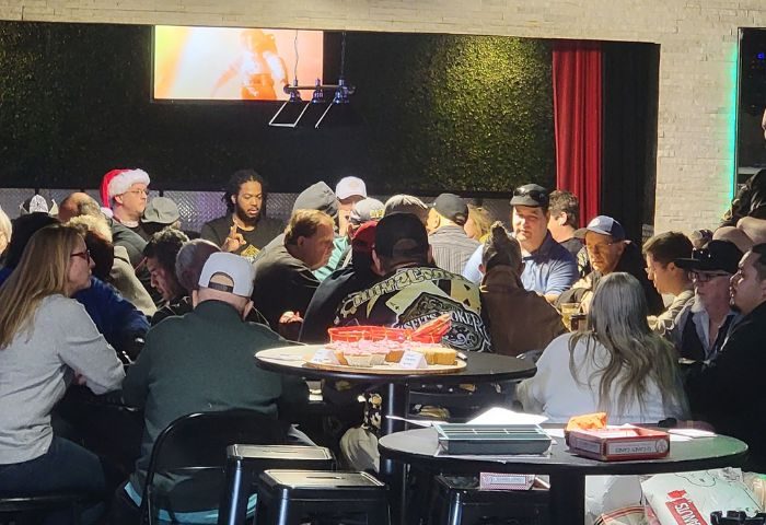 Freezone Gay Bar in Las Vegas: A crowded scene of gay men at tables in a bar setting, enjoying drinks and socializing. Nightlife.