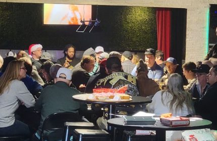 Freezone Gay Bar in Las Vegas: A crowded scene of gay men at tables in a bar setting, enjoying drinks and socializing. Nightlife.