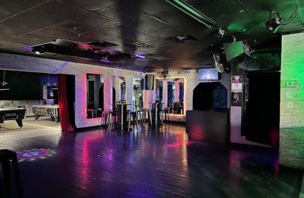 Interior of FreeZone Gay Bar in Las Vegas. Pool tables, bar stools, tables, mirrors, and colorful lighting. Gay travel destination.