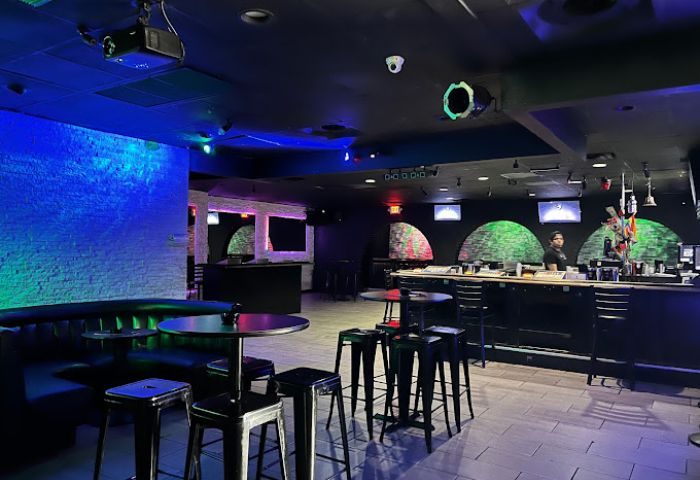 Freezone Gay Bar in Las Vegas. Interior view of the bar area with tables, stools, and colorful lighting. A popular gay nightlife spot.