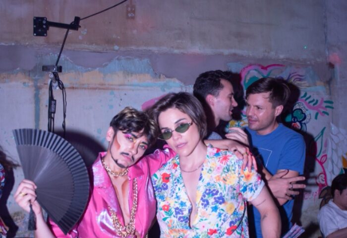 Gay nightlife in Ho Chi Minh. Two stylish gay men pose at a party. One holds a fan. Gay travel advice, full disclosure.