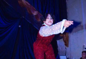 Drag queen performer in Ho Chi Minh City, Vietnam. Red sequin jumpsuit, sheer sleeves. Gay travel advice, nightlife. Full Disclosure.