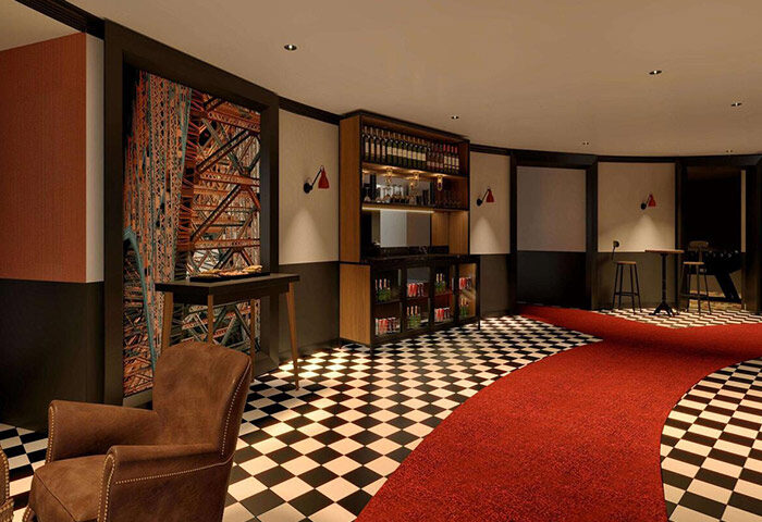Fun design at Mercure Paris Centre Tour Eiffel, a gay-friendly hotel in Paris. Bar, Eiffel Tower mural, & checkered floor create a stylish vibe.