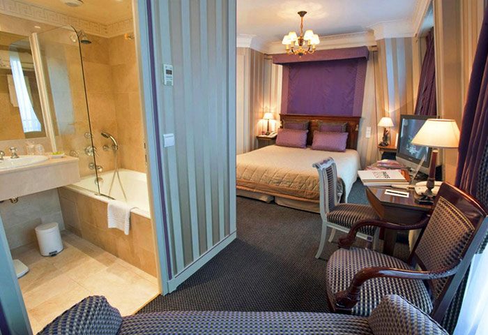 Hotel Napoleon Paris room with fun design. Gay-friendly city center hotel features a bedroom with desk and ensuite bathroom with tub.