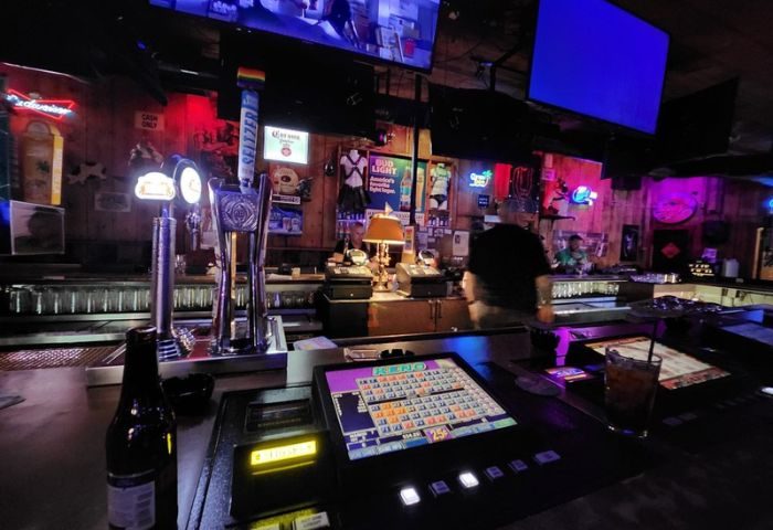 Fun Hog Ranch gay bar in Las Vegas. Interior shot of the bar with beer taps, gaming machines, and neon signs. Gay travel advice.