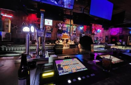 Fun Hog Ranch gay bar in Las Vegas. Interior shot of the bar with beer taps, gaming machines, and neon signs. Gay travel advice.