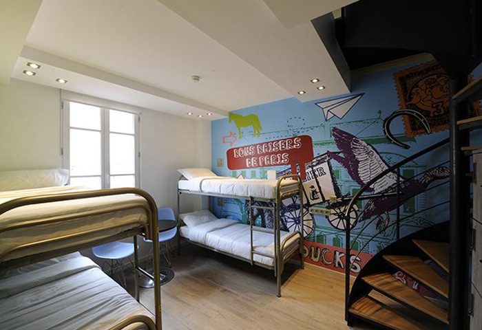 The 3 Ducks Eiffel Tower by Hiphophostels gay hostel dorm room. Bunk beds, spiral staircase, Paris themed mural. Fun party hostel for travellers.