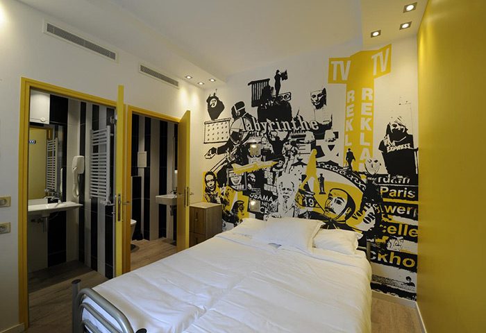 The 3 Ducks Eiffel Tower by Hiphophostels private room. Fun party hostel with a bed, mural, and bathroom for gay travelers.