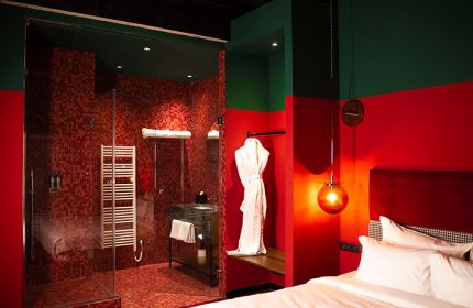 Stories Hotel Budapest: Fun, trendy design in a cheap hotel with great reviews. Red-tiled bathroom and shower, modern bedroom. Gay travel.