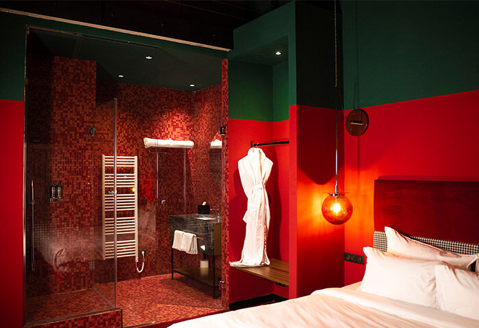 Stories Hotel Budapest: Fun, trendy design in a cheap hotel with great reviews. Red-tiled bathroom and shower, modern bedroom. Gay travel.