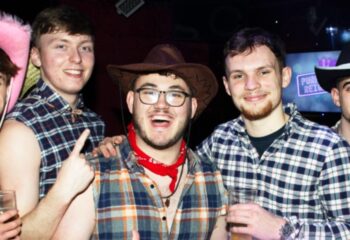 Gay Manchester nightlife: Group of gay men in cowboy attire at G-A-Y Manchester bar, enjoying a night out. Travel advice for gay men.