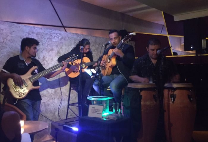 Live music at Garbo Piano Bar, a gay bar in Puerto Vallarta. Four musicians play bass, guitar, congas, and sing. Nightlife scene.