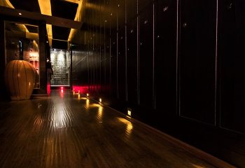 Gateway Sauna Hong Kong locker room. Top gay sauna cruise club near gayborhood. Dark wood lockers, shiny floors, red lights, and a vase.
