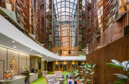 Ibis Styles Bangkok Silom lobby interior. Stylish, budget-friendly gay hotel in Silom, Thailand. Modern design with plants and glass roof.