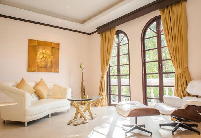 Poseidon Boutique Hotel room in Pattaya, Thailand. Gay-concept hotel near Dongtan Beach, Jomtien. Modern design with sofa and windows.