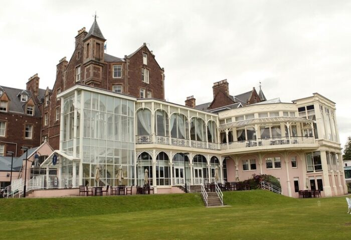 Crieff Hydro, a gay-friendly hotel. Exterior view of the hotel with its glass-enclosed structures and well-manicured lawn. Travel advice.