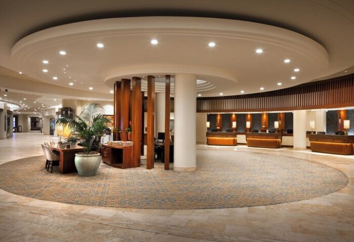 Sheraton Waikiki Beach Resort lobby. Gay-friendly hotel with a circular design, wooden accents, and reception desks. Great for gay travel.