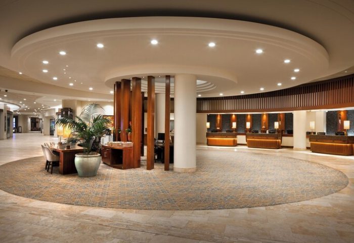 Sheraton Waikiki Beach Resort lobby. Gay-friendly hotel with a circular design, wooden accents, and reception desks. Great for gay travel.
