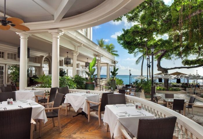Moana Surfrider, A Westin Resort & Spa, Waikiki Beach outdoor dining. Gay-friendly hotel with ocean views, tables, and chairs.