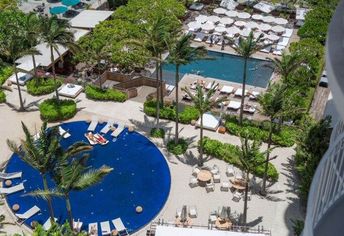 Hilton Vacation Club The Modern Honolulu: Aerial view of a gay-friendly hotel's pools, palm trees, lounge chairs, and umbrellas.