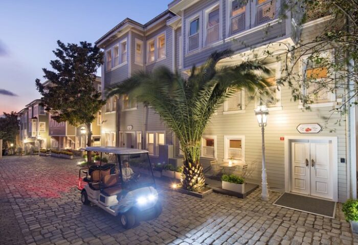 Hagia Sofia Mansions Istanbul, a gay-friendly hotel. Features a golf cart on a cobblestone street at dusk. Curio Collection by Hilton.