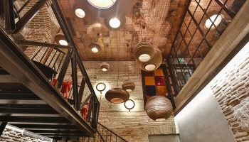 Hotel The Public interior. Gay-friendly hotel's architectural details: exposed brick, metal staircase, and decorative lighting fixtures.