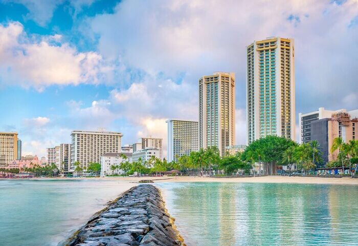 Hyatt Regency Waikiki Beach Resort and Spa view. Gay-friendly hotel on Waikiki Beach, Hawaii. Palm trees, ocean, and city skyline.