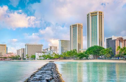 Hyatt Regency Waikiki Beach Resort and Spa view. Gay-friendly hotel on Waikiki Beach, Hawaii. Palm trees, ocean, and city skyline.