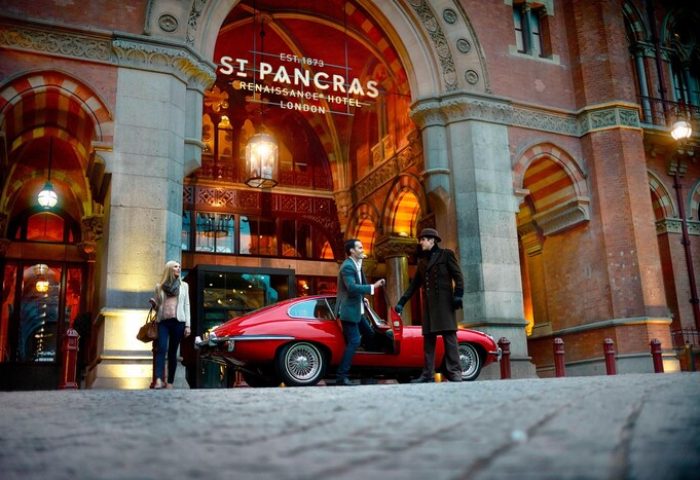 St. Pancras Renaissance Hotel London: Guests arriving in style at this gay-friendly hotel in a red vintage car. Luxury travel experience.