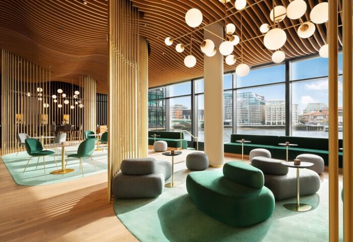 Interior of The Westin London City, a gay-friendly hotel. Modern design with river view, stylish seating, and unique lighting. Luxury travel.