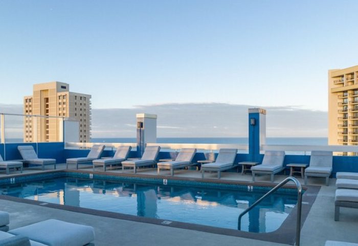 Pacific Monarch Hotel's rooftop pool. Loungers surround the pool with ocean views. A gay-friendly hotel for your travel plans.
