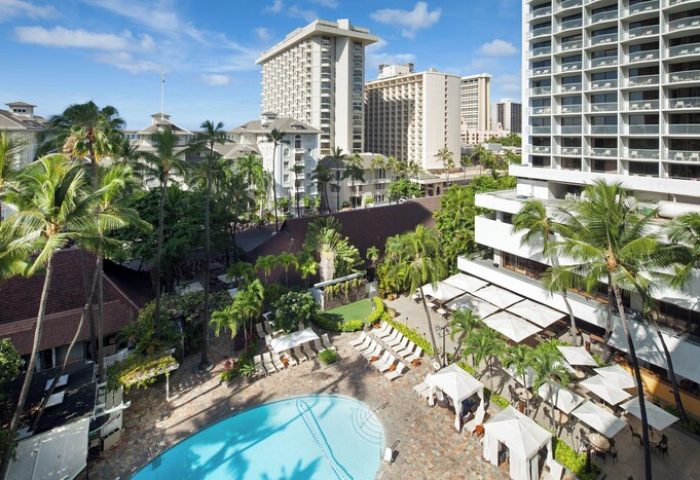 Aerial view of Sheraton Princess Kaiulani, a gay-friendly hotel. Pool, palm trees, and Waikiki skyline are visible. Perfect for gay men travel.