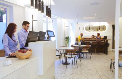 The Z Hotel Trafalgar lobby. Staff at the reception. Guests at the bar. Gay-friendly hotel interior.