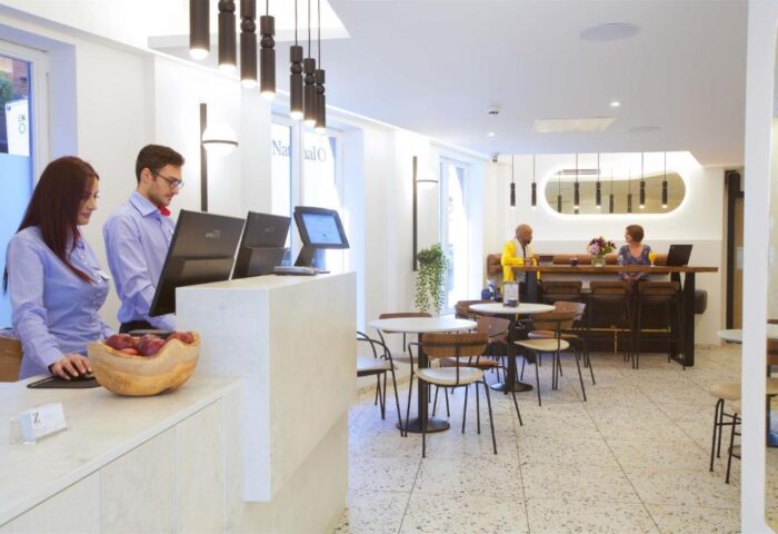 The Z Hotel Trafalgar lobby. Staff at the reception. Guests at the bar. Gay-friendly hotel interior.
