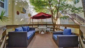 The Grand Resort and Spa's gay-friendly hotel outdoor patio. Lounge seating, table, and umbrella offer a relaxing space for gay men.