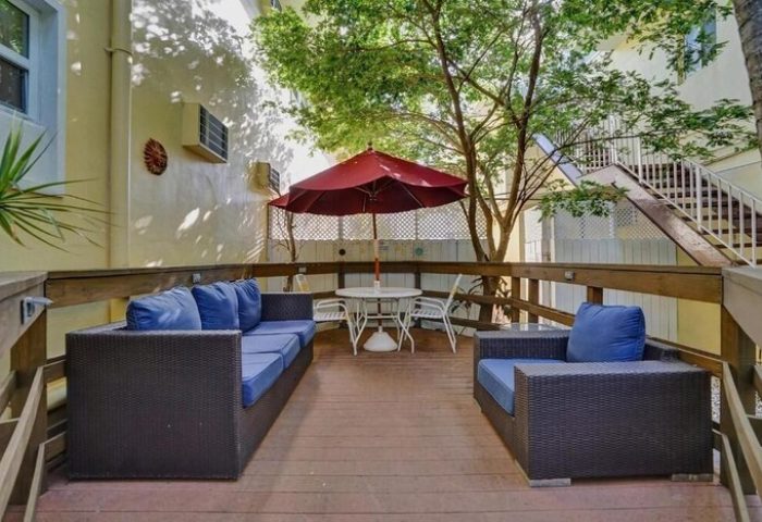 The Grand Resort and Spa's gay-friendly hotel outdoor patio. Lounge seating, table, and umbrella offer a relaxing space for gay men.