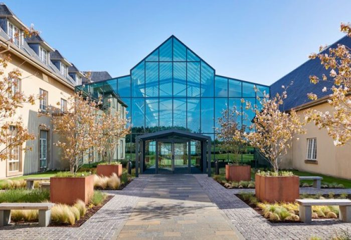 Fairmont St Andrews, Scotland: Gay-friendly hotel with glass facade. Luxury travel destination for gay men. Modern architecture, lush landscape.