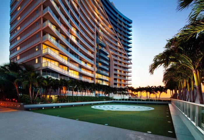 W Fort Lauderdale, a gay-friendly hotel. Exterior view with palm trees, lawn, and modern architecture. Ideal for gay travel and vacation.