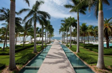 Casa Marina Key West, a gay-friendly hotel. Palm-lined path with water features leads to the beach. Curio Collection by Hilton.
