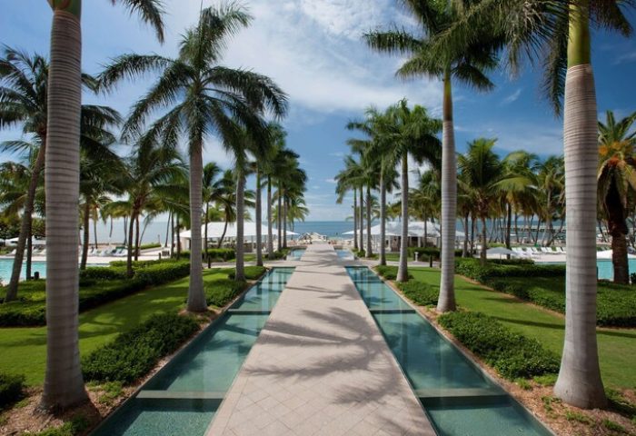 Casa Marina Key West, a gay-friendly hotel. Palm-lined path with water features leads to the beach. Curio Collection by Hilton.