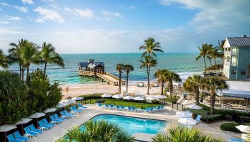The Reach Key West, Curio Collection by Hilton, a gay-friendly hotel. Pool, beach, pier, and palm trees create a tropical paradise.