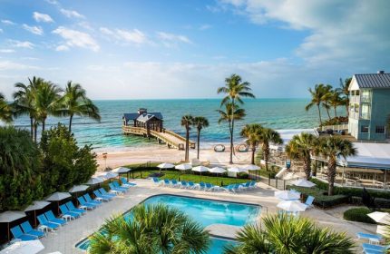 The Reach Key West, Curio Collection by Hilton, a gay-friendly hotel. Pool, beach, pier, and palm trees create a tropical paradise.