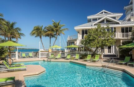 Hyatt Centric Key West Resort pool. Gay-friendly hotel with palm trees, lounge chairs, umbrellas, and ocean views. Perfect for gay men travel.
