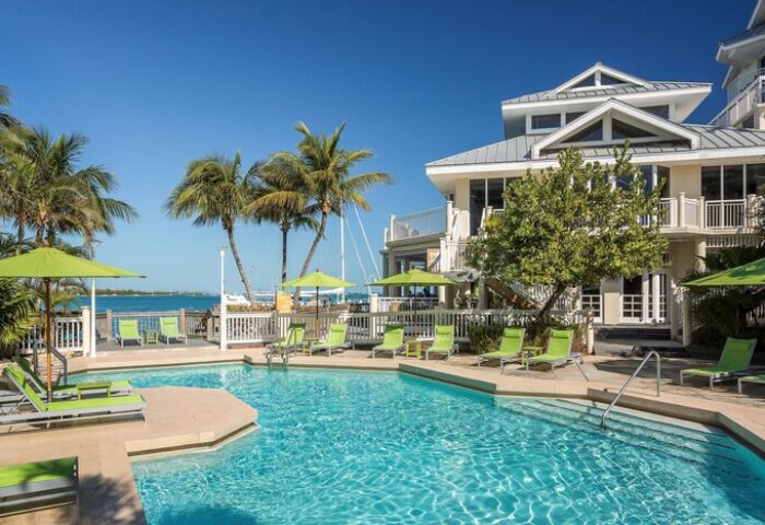 Hyatt Centric Key West Resort pool. Gay-friendly hotel with palm trees, lounge chairs, umbrellas, and ocean views. Perfect for gay men travel.