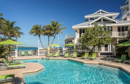 Hyatt Centric Key West Resort pool. Gay-friendly hotel with palm trees, lounge chairs, umbrellas, and ocean views. Perfect for gay men travel.