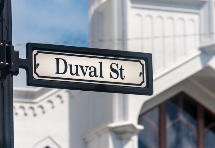 Duval St sign near H2O Suites, a gay-friendly hotel. Key West's iconic street, known for its vibrant nightlife and LGBTQ+ scene.