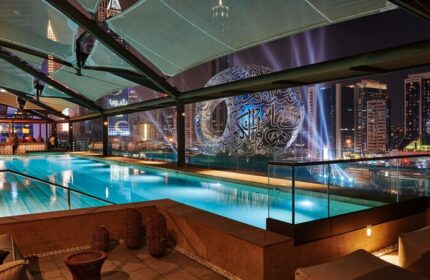 25hours Hotel One Central gay-friendly hotel pool at night. Dubai skyline view, perfect for gay travelers seeking luxury and vibrant nightlife.