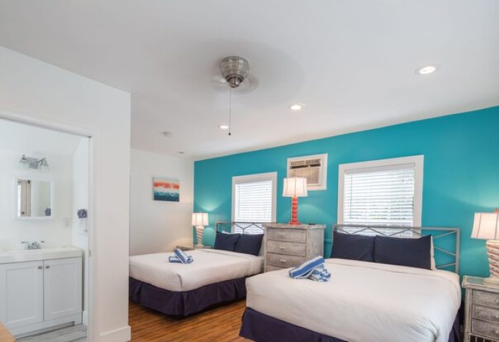 Wicker Guesthouse gay-friendly hotel room. Two beds, blue accent wall, bathroom. Comfortable stay for gay travelers.